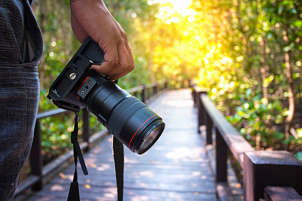 man holding his camera on walkway during his travel
